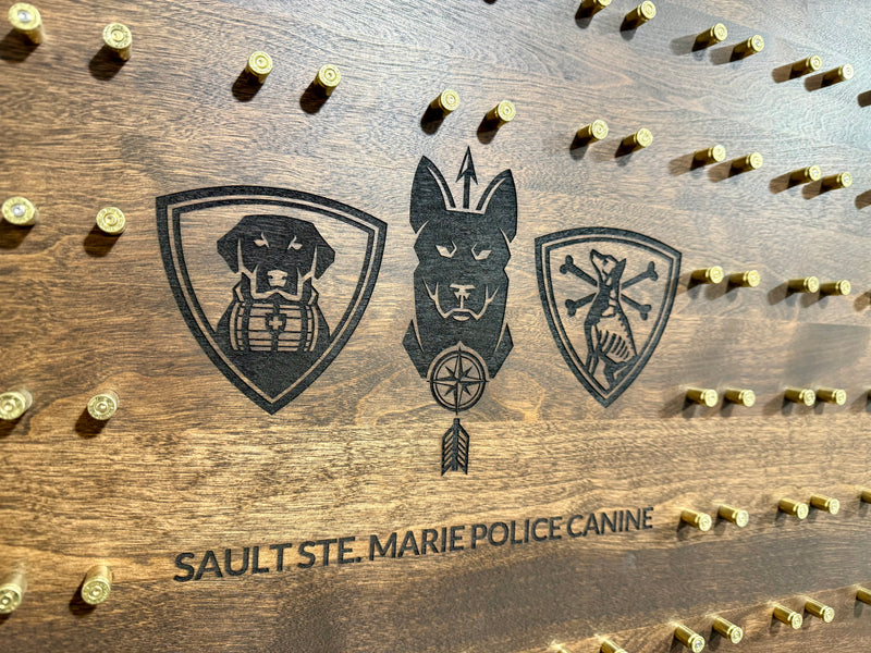Wooden Challenge coin display with engraved dog illustrations and 'Sault Ste. Marie Police Canine' text.